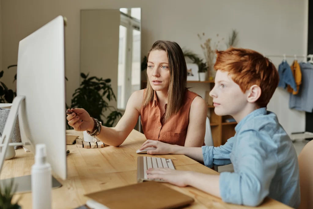 mãe e filho utilizando o computador para estudar