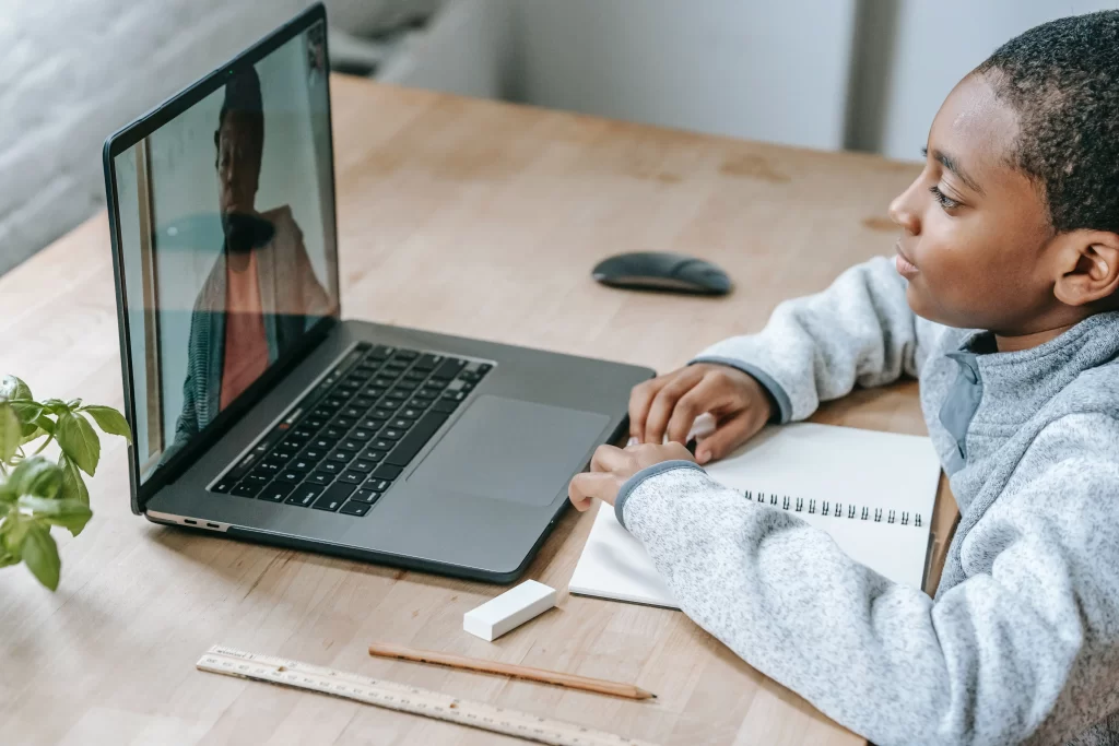 menino assistindo aula por meio da videochamada