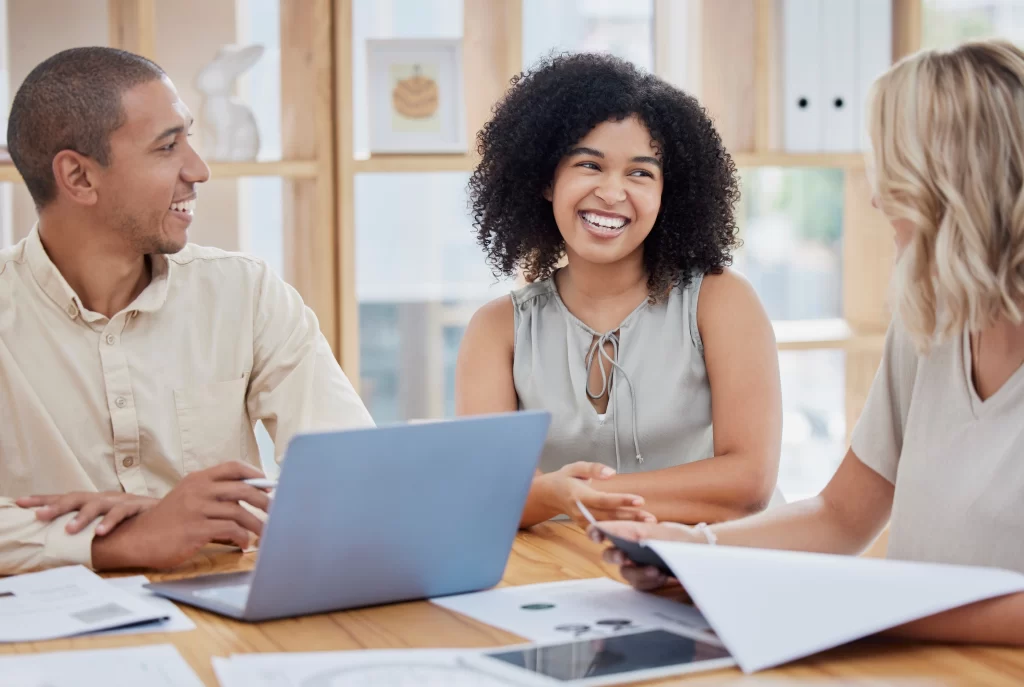 Pessoas sorrindo no ambiente de trabalho, pensando em mudanças digitais e colaborando juntas.
