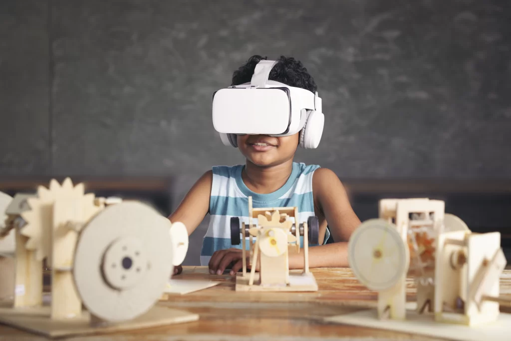 Menino negro feliz utilizando óculos de realidade virtual aumentada enquanto estuda.
