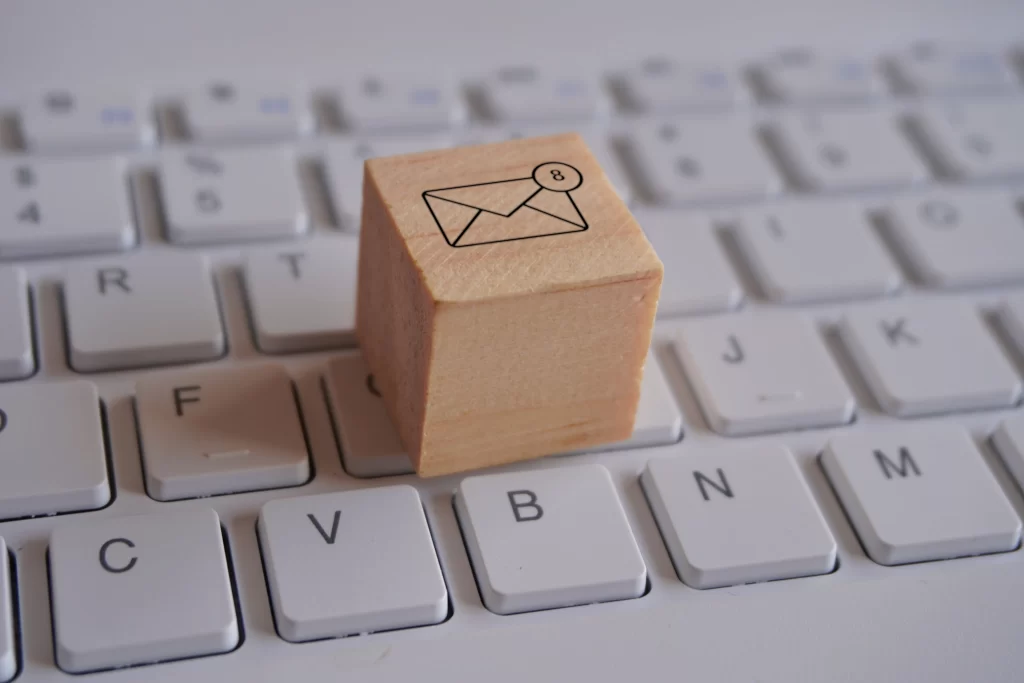 Imagem de um teclado com um bloco de madeira com um símbolo de e-mail com notificação estampado.