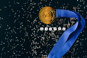 medalha de primeiro lugar com letras formando a palavra "winner" logo abaixo